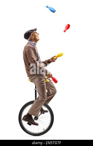 Elderly man a riding a unicycle and juggling isolated on white ...