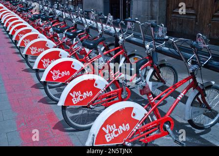 Viu  BiCiNg ,Biking -- Barcelona, line of matching red and white bicycles at a bicycle renting station. Stock Photo