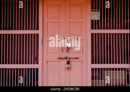 A shabby pink wooden door with two old latches on, in Mandawa haveli in Rajasthan India Stock Photo