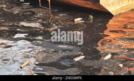 Dirty sea with plastic bottles by the ship. Stock Photo