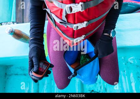 Top view of an unrecognizable marine biologist holding a mobile on a boat Stock Photo