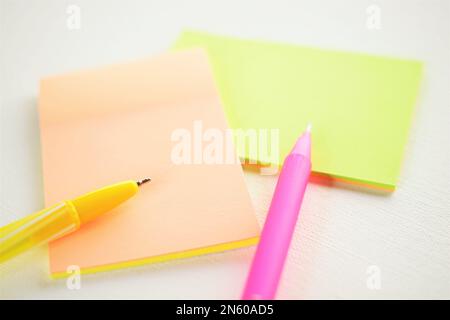 Yellow and pink ballpoint pen and notes on white paper. Stock Photo