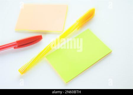 Yellow and red ballpoint pen and notes on white paper. Stock Photo