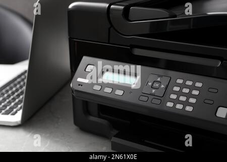 New modern printer and laptop on grey table, closeup Stock Photo