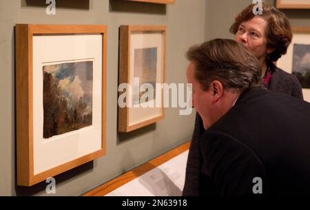 British Prime Minister David Cameron is shown the newly discovered previously unknown oil sketch painting by John Constable entitled 'Landscape with a Kiln', at left, from 1821 or 1822 by Head Painting Conservator Nicola Costaras, right, as an additional part of his visit to the 'Masterpieces of Chinese Painting: 700-1900' at the Victoria & Albert Museum in London, Thursday, Nov. 28, 2013. The museum said it was discovered when conservators attempted to remove the lining on the back of 'Branch Hill Pond: Hampstead', another work by the English romantic painter known for his landscapes, while p