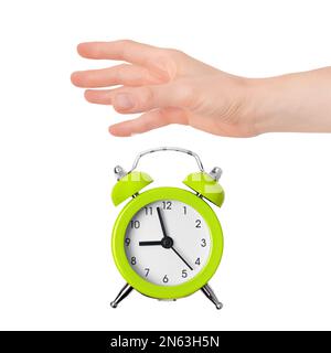 Hand dropping lime green metal alarm clock isolated on white background. Concept of time. On the clock face, it's five minutes to nine in the morning. Stock Photo