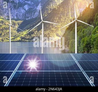 Alternative energy sources. Wind turbines installed in water, solar panels on foreground Stock Photo