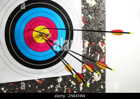 Many arrows in archery target on wall Stock Photo