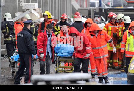 Rescue workers carry a stretcher with a victim outside the Maxima supermarket in Riga, Latvia, Friday, Nov. 22, 2013. At least 32 people died, including three firefighters, after an enormous section of roof collapsed at a Latvian supermarket in the country's capital, emergency medical officials said Friday. The reason for the collapse during shopping rush-hour Thursday was still not known but rescue and police officials said that possible theories include building's design flaws and poor construction work. (AP Photo/ Roman Koksarov)