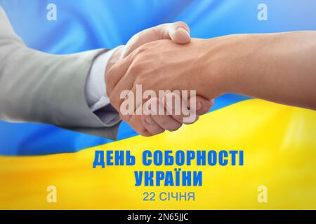 Unity Day of Ukraine. People shaking hands, text written in Ukrainian and national flag on background Stock Photo