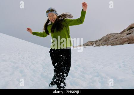 Asian woman playing in the snow, Antarctica Stock Photo