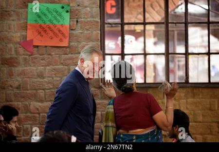 Britain's Prince Charles laughs as he speaks with a school official at Katha Lab School, a school for underprivileged children, in New Delhi, India, Friday, Nov. 8, 2013. Charles and his wife Camilla, the Duchess of Cornwall, are on a nine-day visit to India. (AP Photo/Saurabh Das)