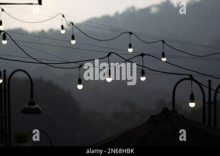 Caffe lights hanging outside the room at dusk Stock Photo
