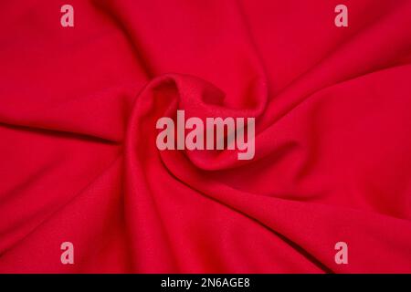 Red fabric background. Red cloth waves background texture. Red fabric cloth textile material. Stock Photo