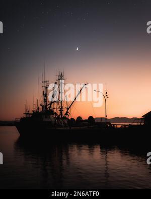 Silhouette boat at sunset Stock Photo