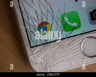Shattered phone screen displaying the Google Chrome logo Stock Photo