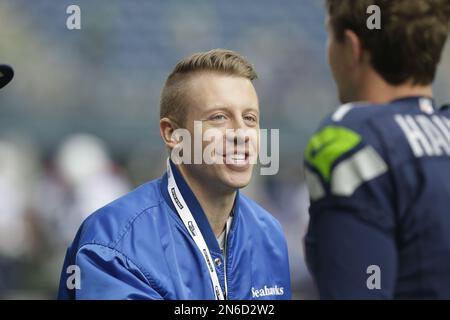 Seattle hip hop and rap singer Macklemore greets Seattle Seahawks  quarterback Russell Wilson before an NFL football game between the Seahawks  and Tennessee Titans, Sunday, Oct. 13, 2013, in Seattle. (AP Photo/Elaine