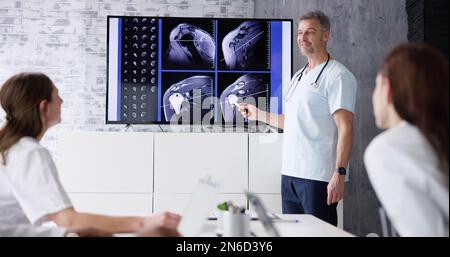 Physician Doctors Looking At Shoulder MRT Scan Stock Photo