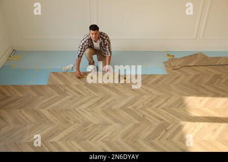 Professional worker installing new parquet flooring indoors, above view Stock Photo