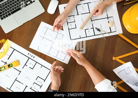 People working with construction drawings and tools  at wooden table, top view Stock Photo