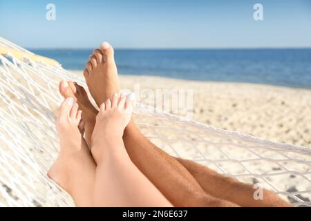 Couple relaxing in hammock on beach, closeup Stock Photo