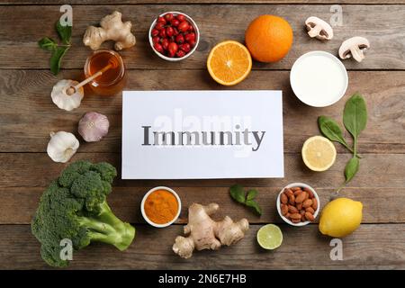 Card with word Immunity and fresh products on wooden table, flat lay Stock Photo