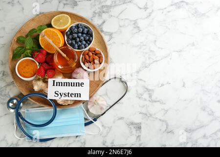 Card with phrase Immune System, medical items and fresh products on light marble table, flat lay. Space for text Stock Photo