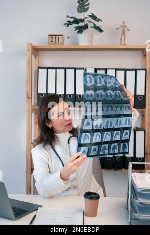 Doctor examines MRI scan of rib cage and neck of patient, holding in hands. Instrumental diagnostics of disease, concept photo. Copy space Stock Photo