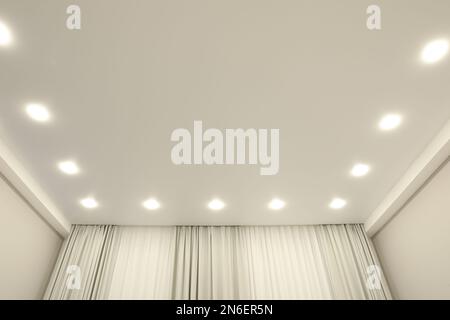 White stretch ceiling with spot lights in room Stock Photo
