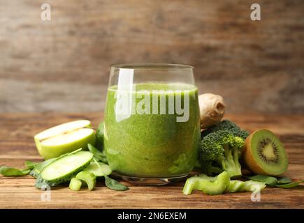 Green juice and fresh ingredients on wooden table Stock Photo