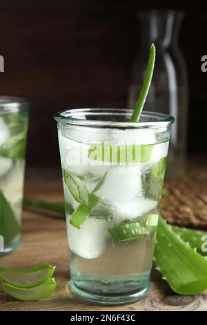 Fresh aloe drink with ice cubes on wooden table Stock Photo
