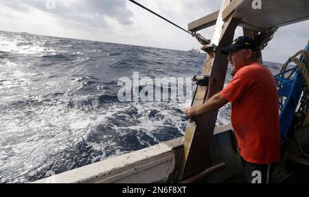 Italian fisherman Michele Burgio looks out from a fishing boat at the