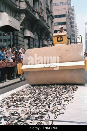 Counterfeit Cartier watches are crushed by a steamroller next to