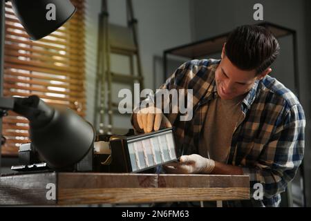 Professional repairman fixing modern printer in office Stock Photo