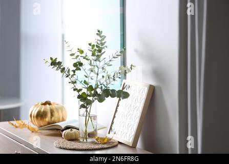Beautiful eucalyptus branches and decor on cabinet in modern room. Interior design Stock Photo