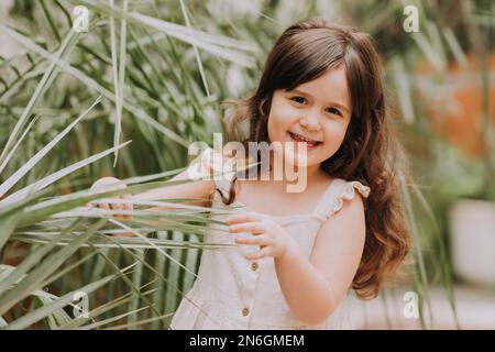a little girl walks in the botanical garden. happy baby and palm trees Stock Photo