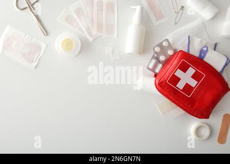 Equipment for first aid cures on table with carrying bag on white table. Horizontal composition. Top view. Stock Photo