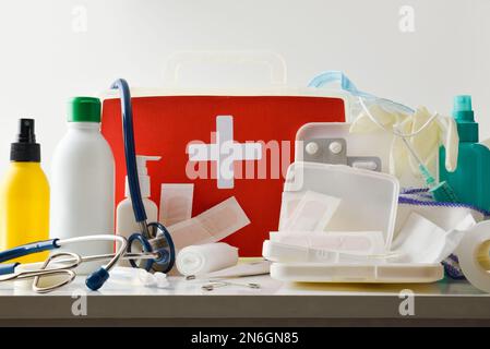 Assortment of basic first aid portable medical assistance equipment on white table isolated. Horizontal composition. Front view. Stock Photo