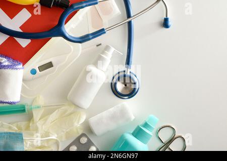 Assortment of basic first aid portable medical assistance equipment on white table. Horizontal composition. Top view. Stock Photo