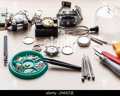 spare parts, tools and old watches on wooden table in watchmaker workshop Stock Photo