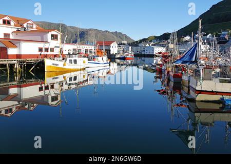 Harbour with small fishing boats reflected in the calm water, Honningsvag, Finnmark, North Cape, Norway Stock Photo