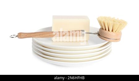 Cleaning brush and soap bar for dish washing on plates against white background Stock Photo