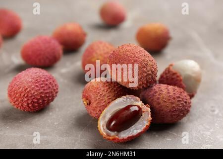 Fresh ripe lychee fruits on grey table Stock Photo