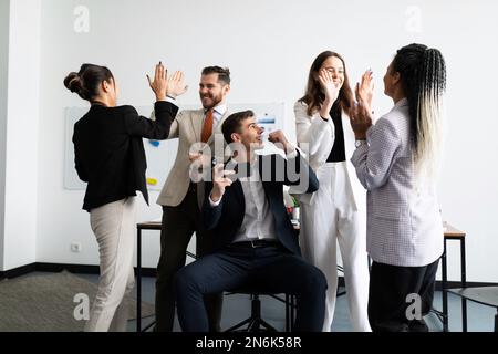 a team of successful programmers and managers in the office rejoices at the victory in the tender Stock Photo