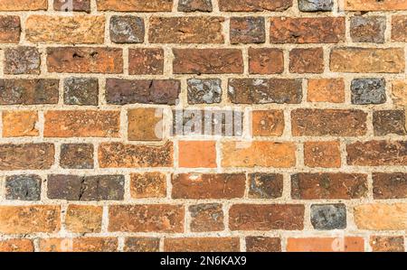 Brick wall in different shades of orange, brown and gray. Stock Photo