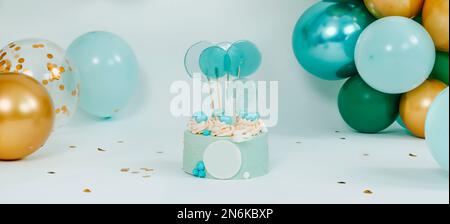 a blue cake on a white background in front of an elegant arrangement of balloons of different colors for a birthday party a wedding or a baby cake sma Stock Photo