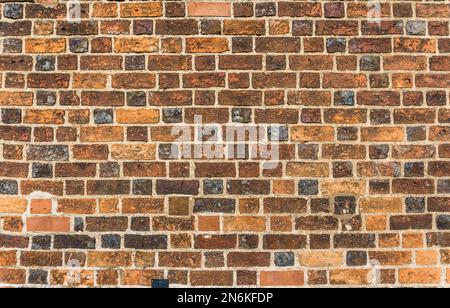 Brick wall in different shades of orange, brown and gray. Stock Photo