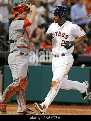 Houston Astros' L.J. Hoes (28) is congratulated by teammate Jose Altuve  (27) after scoring on a single by Brandon Barnes against the Oakland  Athletics during the seventh inning of a baseball game