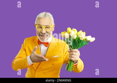 Smiling senior man in suit offer flowers bouquet Stock Photo