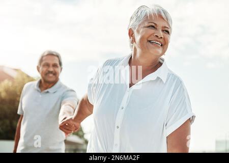 Senior couple holding hands in park for outdoor wellness, happy retirement and valentines love in Mexico. Mexican elderly woman with her partner Stock Photo